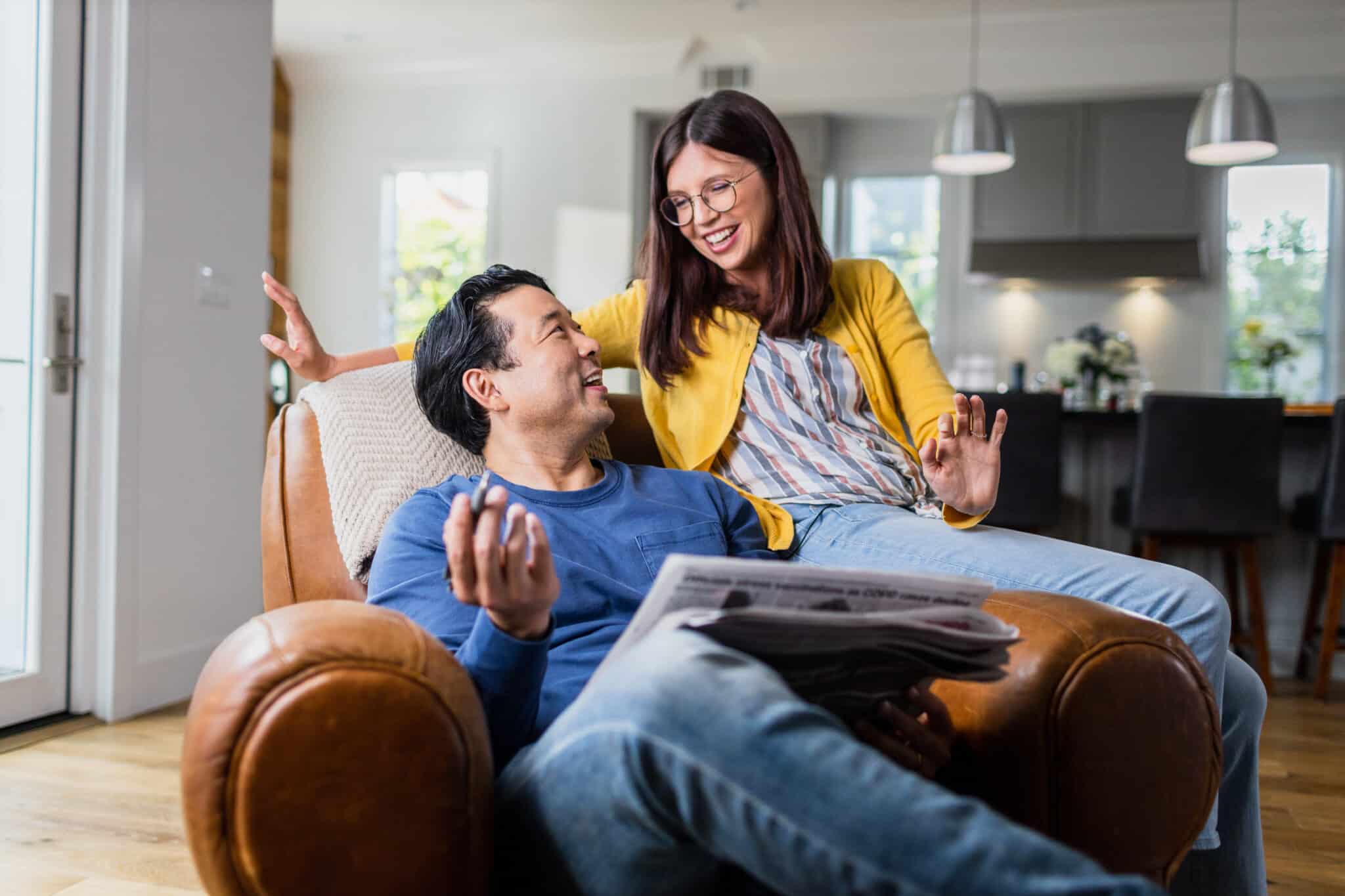 Couple sitting comfortably on an armchair together, smiling