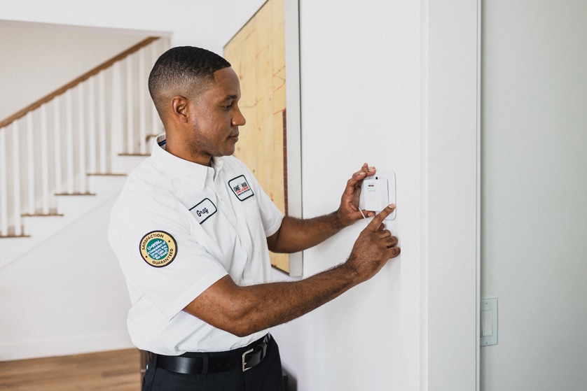 One Hour Heating & Air technician working on a Savannah, GA resident's thermostat.